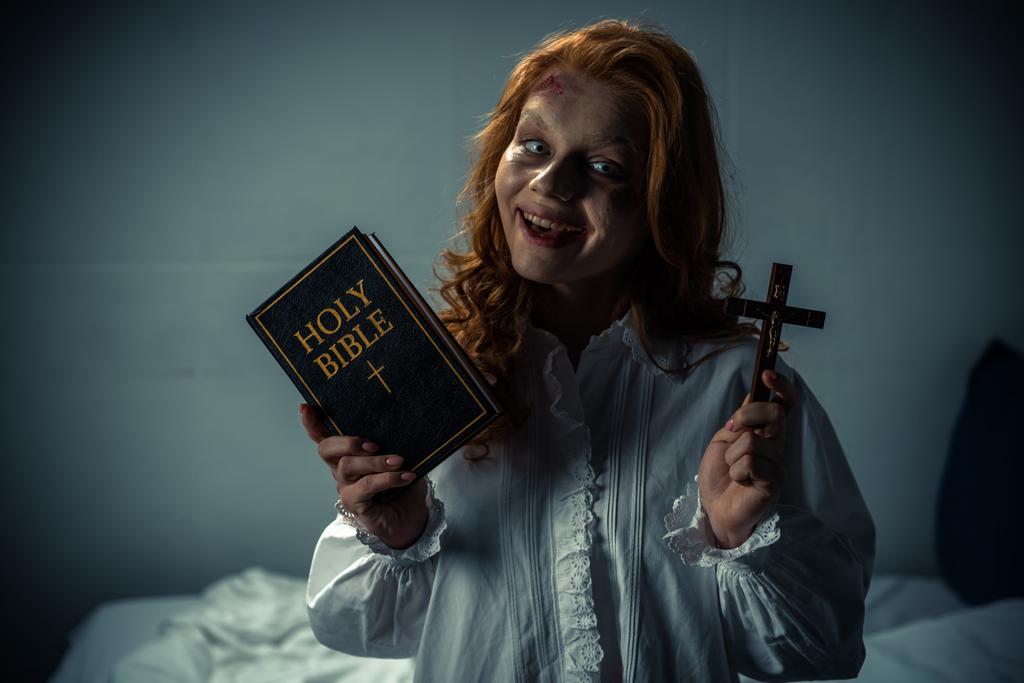 sorridente mulher demoníaca segurando cruz e bíblia santa
  - Foto, Imagem