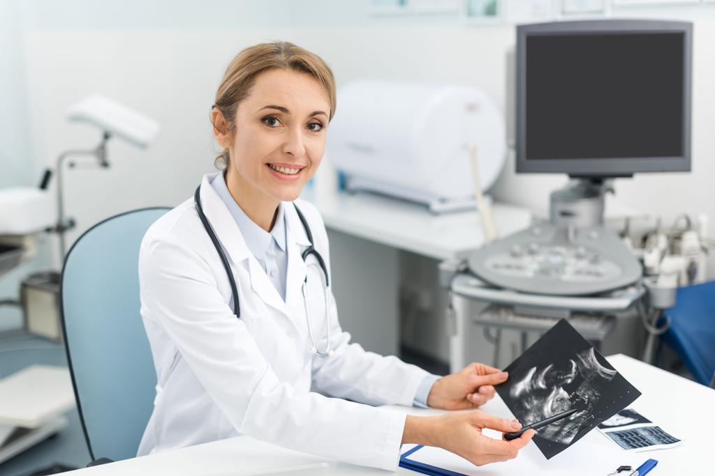 診療所で超音波検査をする専門の女性医師  - 写真・画像
