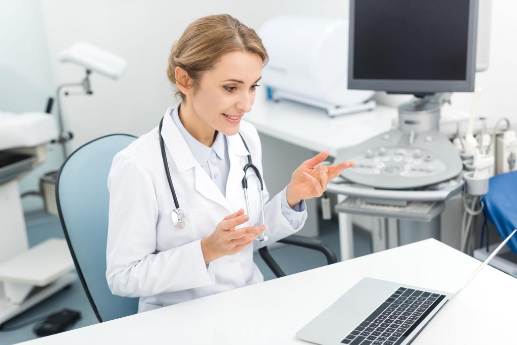 професійний жіночий лікар, що працює на ноутбуці в клініці з ультразвуковим сканером
 - Фото, зображення