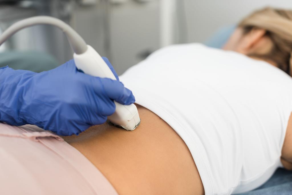 osittainen näkemys naispotilaan munuaisia ultraäänitutkimuksella tutkivasta lääkäristä
 - Valokuva, kuva