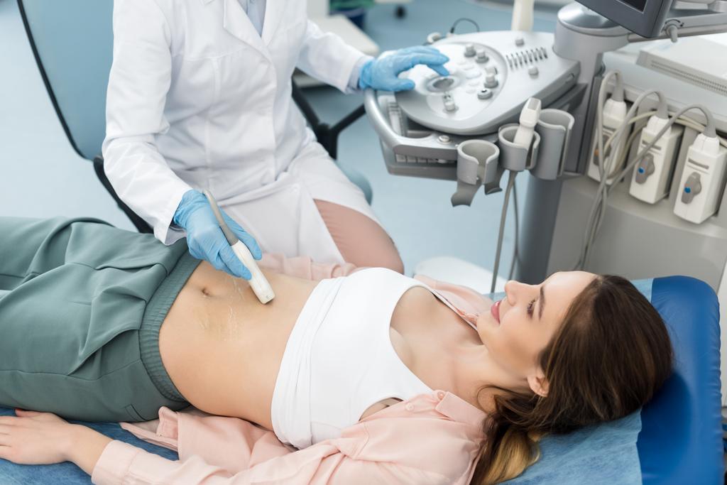 femme médecin examinant l'estomac du patient avec échographie en clinique
  - Photo, image