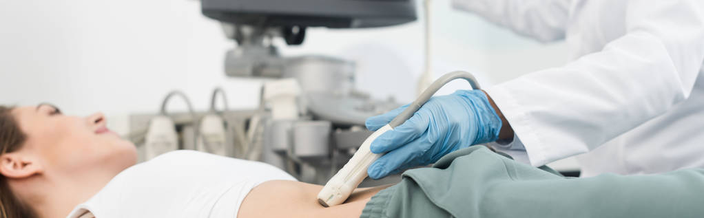 panoramatický snímek lékaře provádějícího ultrazvukové vyšetření žaludku na klinice  - Fotografie, Obrázek