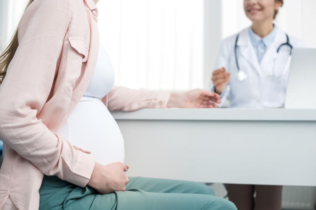 vista recortada de la mujer embarazada joven teniendo consulta con el ginecólogo en la clínica
 - Foto, imagen