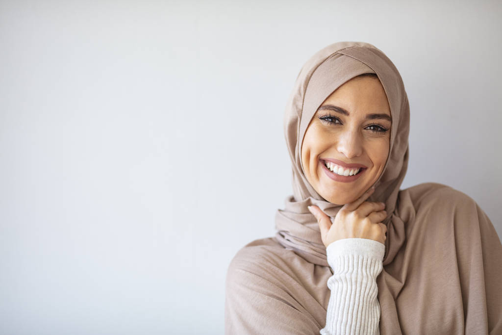 Portrét islámské ženy, usmívající se. Pěkná muslimka. Krásná asijské muslimah žena model pózování na šedé zdi studio. Portrét arabské krásy.  - Fotografie, Obrázek