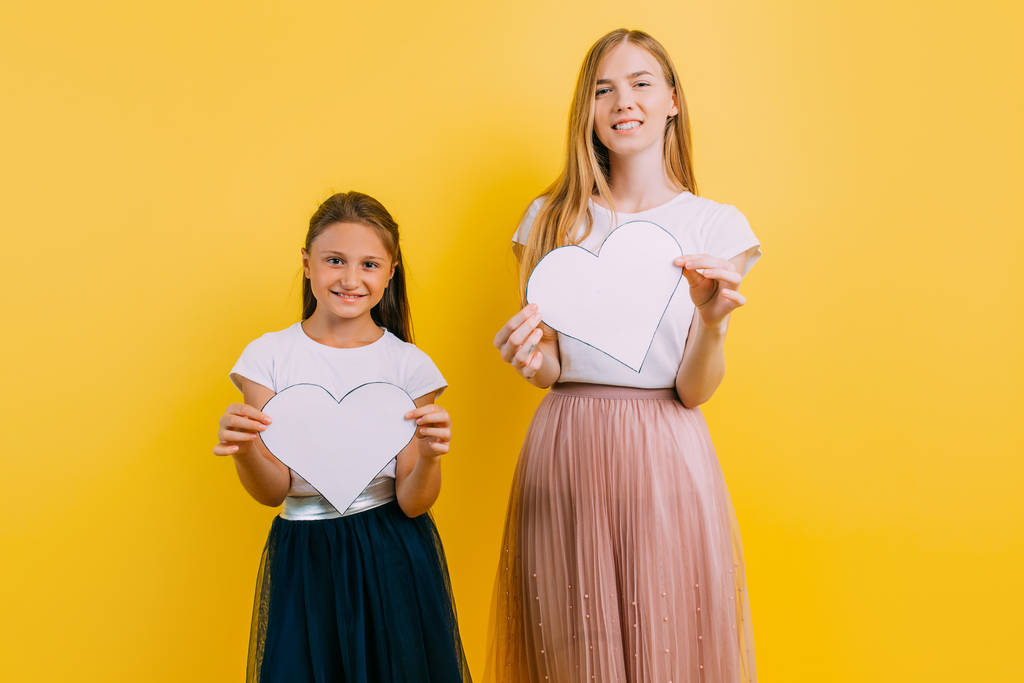 Happy family, mother and daughter with paper hearts in their han - Photo, Image