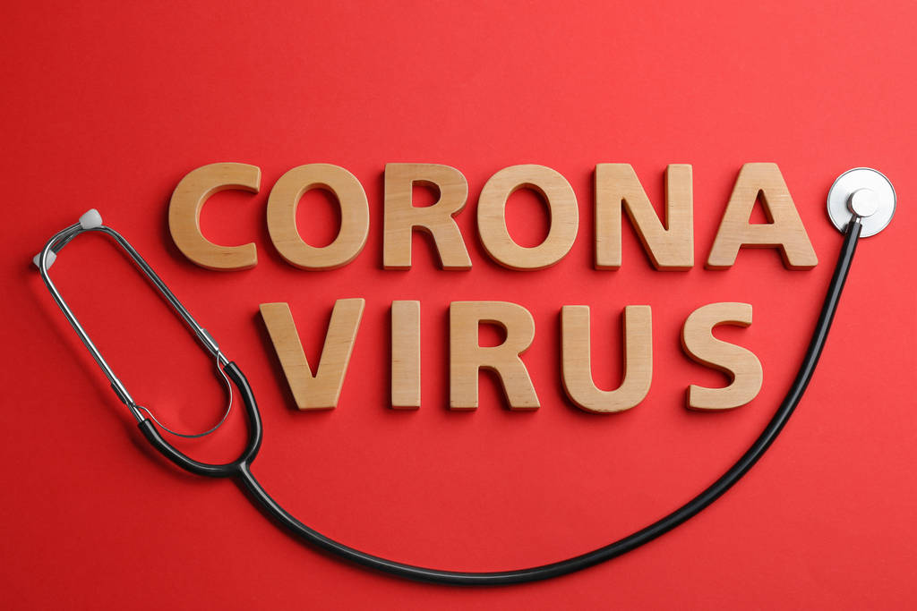 Woorden Corona Virus gemaakt van houten letters en stethoscoop op rode achtergrond, plat gelegd - Foto, afbeelding