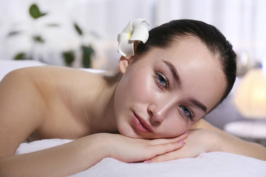 Brunette female with relaxed facial expression lying on a massage table. - Photo, Image