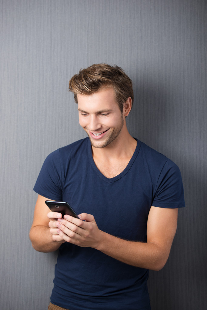 Возбужденный мужчина читает смс на мобильном
 - Фото, изображение
