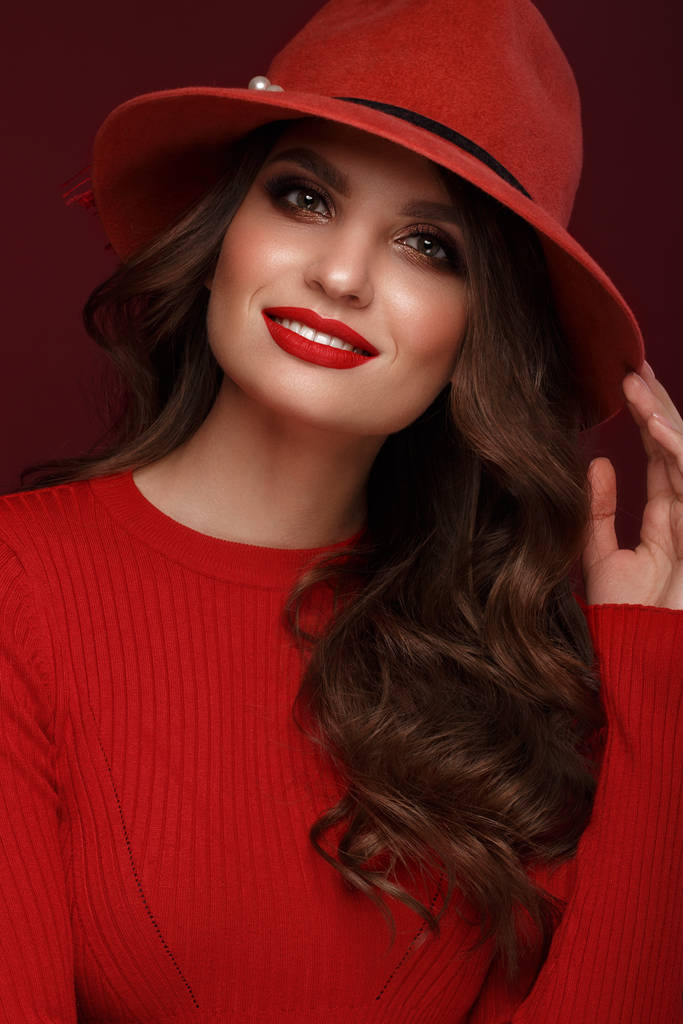 Bella donna sexy in un cappello alla moda, con trucco classico, capelli ondulati e labbra rosse. Bellezza viso
. - Foto, immagini