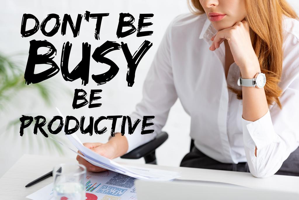 Обрезанный вид бизнесвумен держит досье рядом с графиками и ноутбуком на столе, не быть занятым быть продуктивным иллюстрации
 - Фото, изображение