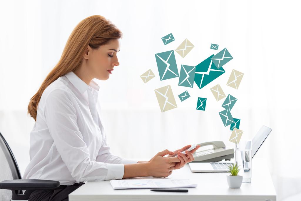 Вид збоку бізнес-леді, використовуючи смартфон біля документів і ноутбук на столі, ілюстрація електронної пошти
 - Фото, зображення