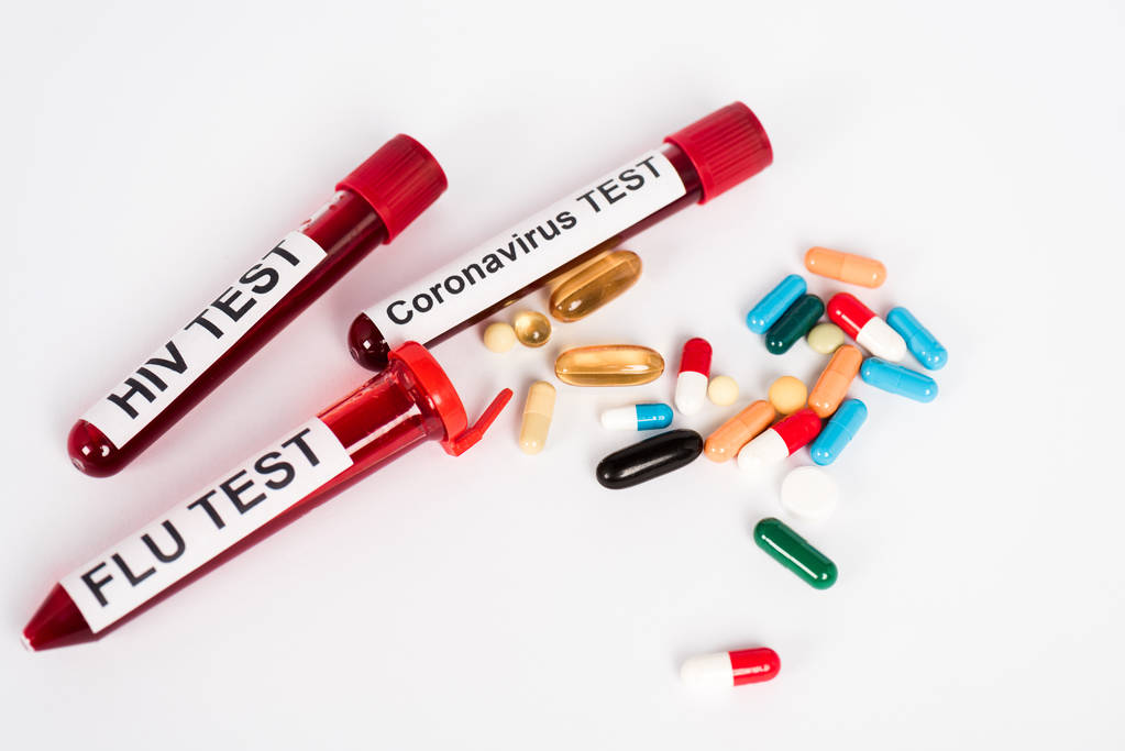 красочные таблетки рядом с образцами с надписью на белом
  - Фото, изображение