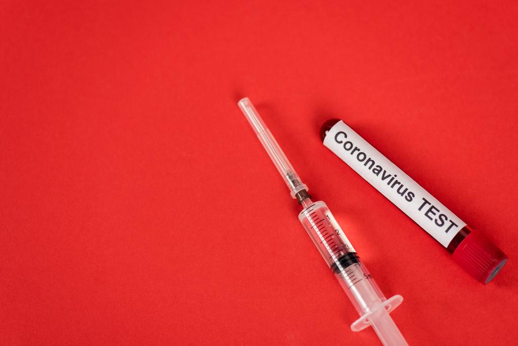 visão superior da amostra com letras de teste de coronavírus perto da seringa no vermelho
 - Foto, Imagem