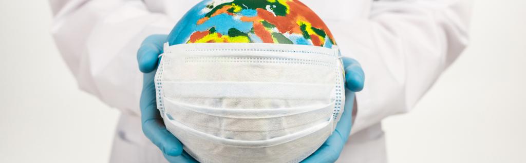 plano panorámico de científico sosteniendo globo en máscara protectora aislado en blanco
  - Foto, Imagen