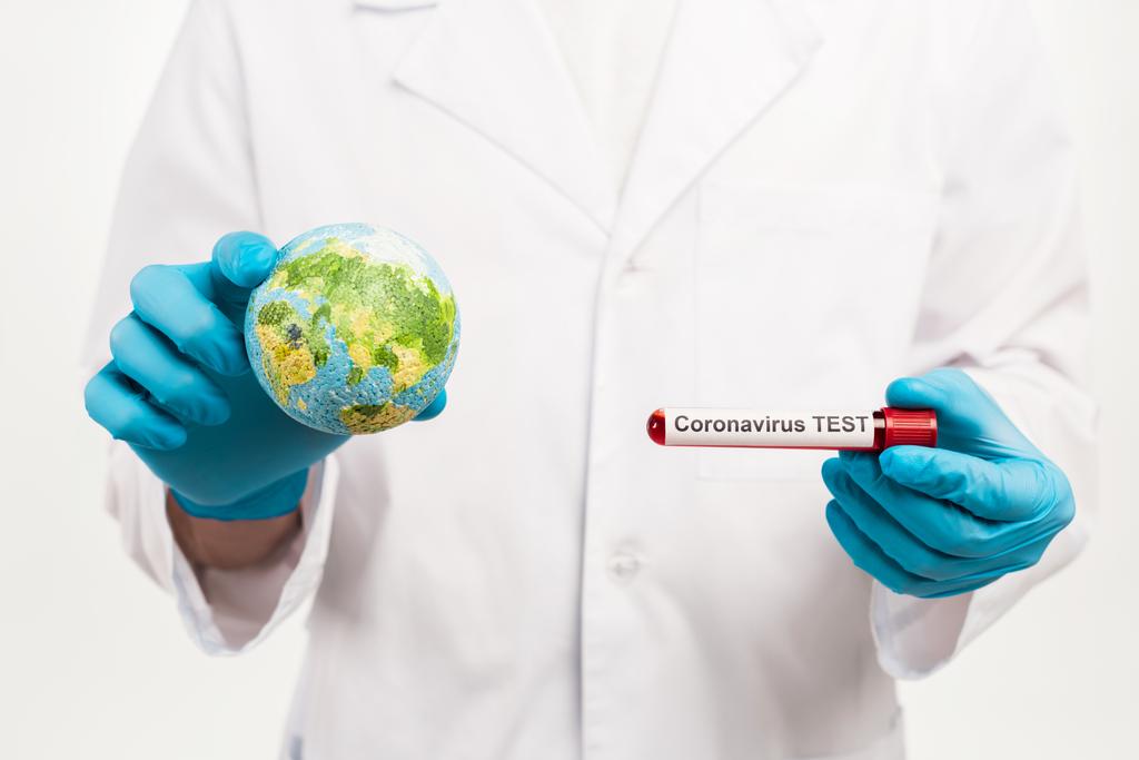 ученый держит маленький глобус и образец с коронавирусом тест надписи изолированы на белом
  - Фото, изображение