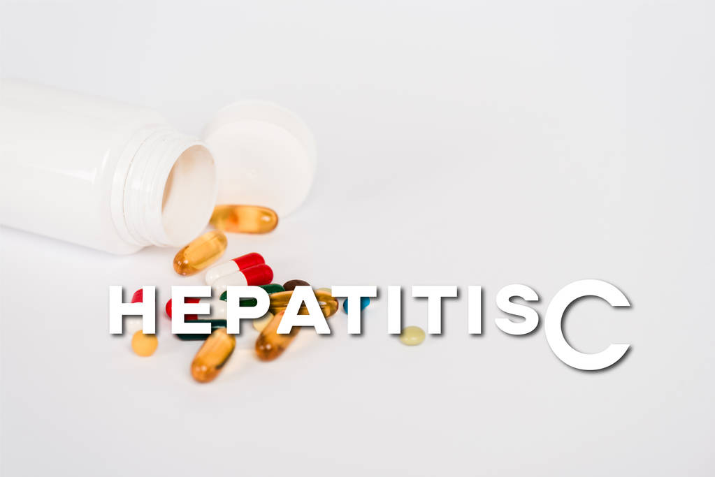 bottle near colorful pills and hepatitis c lettering on white - Photo, Image