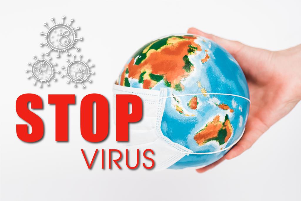 abgeschnittene Ansicht eines Mannes mit Globus in Schutzmaske in der Nähe von Stop-Virus-Schriftzug auf weiß  - Foto, Bild