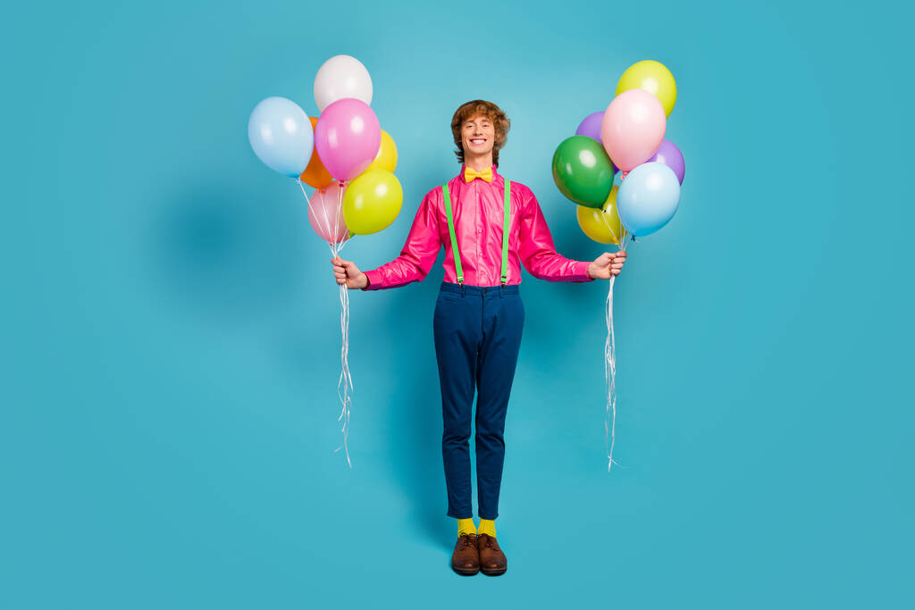 Pełna długość zdjęcie nakładające uroczy mężczyzna przygotować hel prezentuje balony powietrza jego piękny dziewczyna dzień uroczystości nosić nowoczesne różowe spodnie obuwie odizolowany niebieski kolor tło - Zdjęcie, obraz