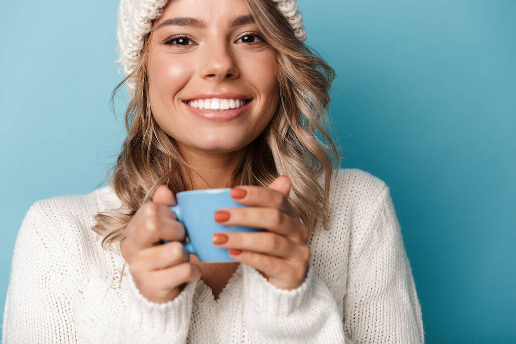 Портрет счастливой блондинки, улыбающейся и держащей чашку
 - Фото, изображение