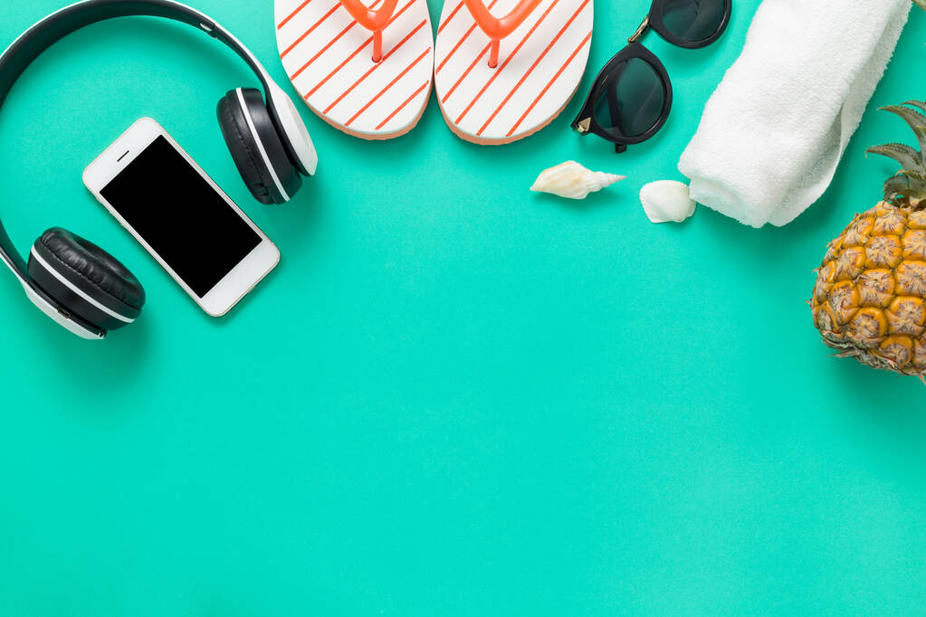 Fond vacances d'été Concept, Téléphone avec ananas, lunettes et tongs Sur fond vert et jaune vue de dessus
 - Photo, image