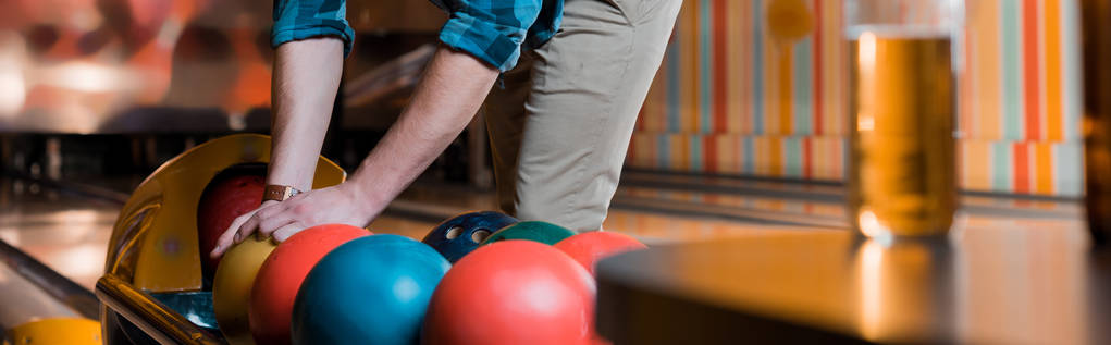 bijgesneden uitzicht op de mens nemen bowling bal, panoramisch schot - Foto, afbeelding
