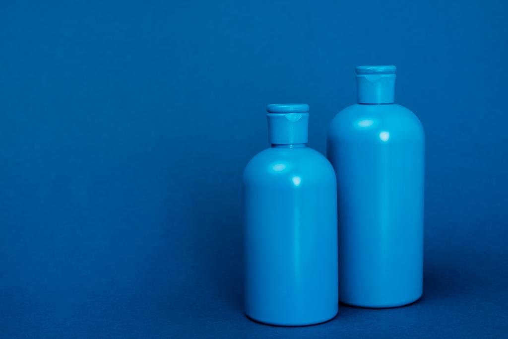 Plastikflaschen mit Shampoo auf blauem Hintergrund mit Kopierraum - Foto, Bild
