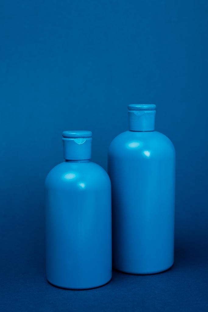botellas de plástico con champú sobre fondo azul con espacio para copiar
 - Foto, imagen