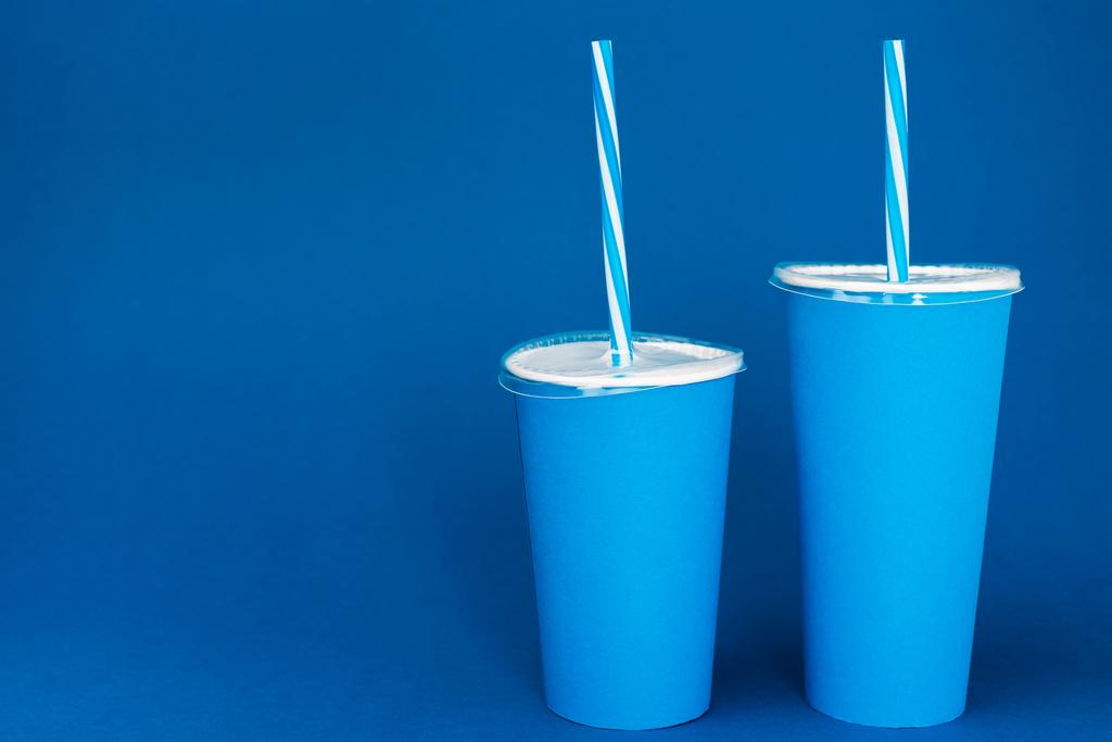 vasos de papel con soda sobre fondo azul con espacio para copiar
  - Foto, Imagen