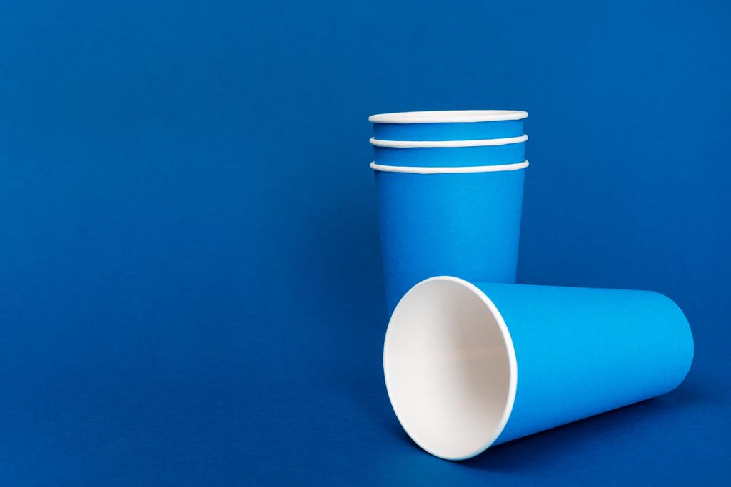 copos de papel vazios no fundo azul com espaço de cópia
  - Foto, Imagem