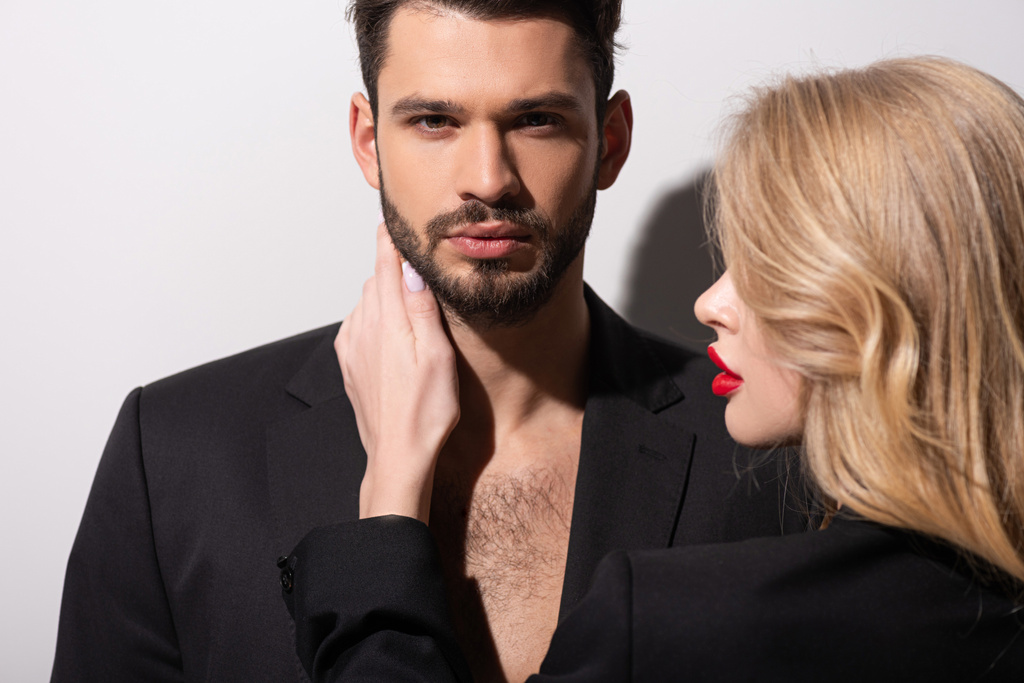 attractive woman with red lips touching handsome boyfriend on white - Photo, Image