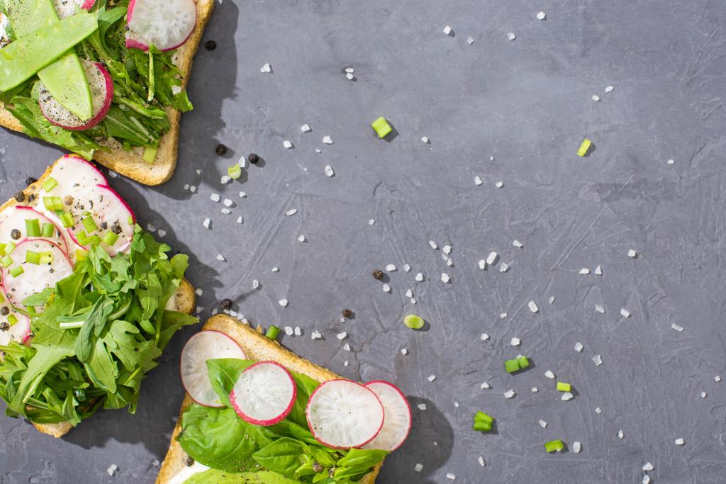 vista superior de sanduíches orgânicos com legumes na mesa de pedra com pimenta e sal
 - Foto, Imagem
