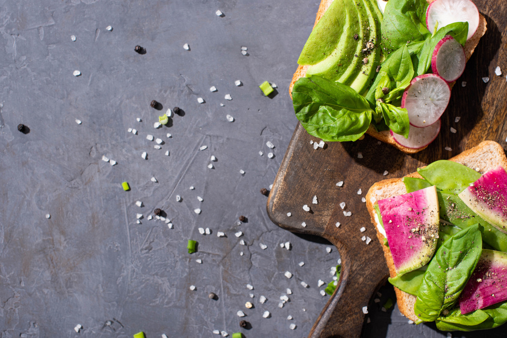 κορυφαία άποψη των υγιεινών σάντουιτς με λαχανικά σε ξύλινο πίνακα με πιπέρι και αλάτι - Φωτογραφία, εικόνα