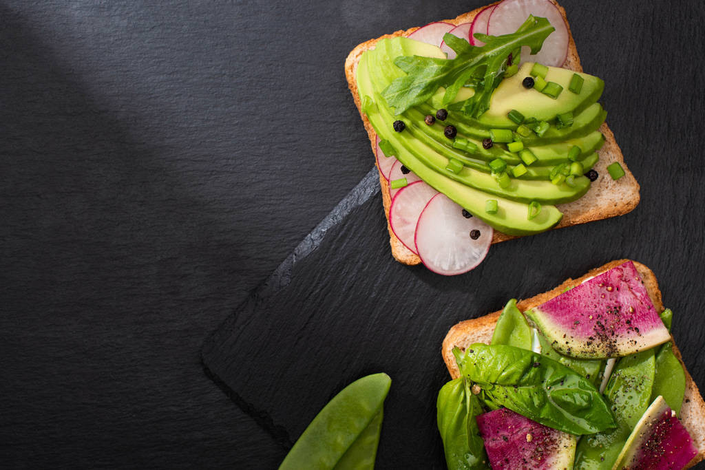 widok z góry organiczne kanapki ze świeżymi warzywami na kamiennej desce  - Zdjęcie, obraz