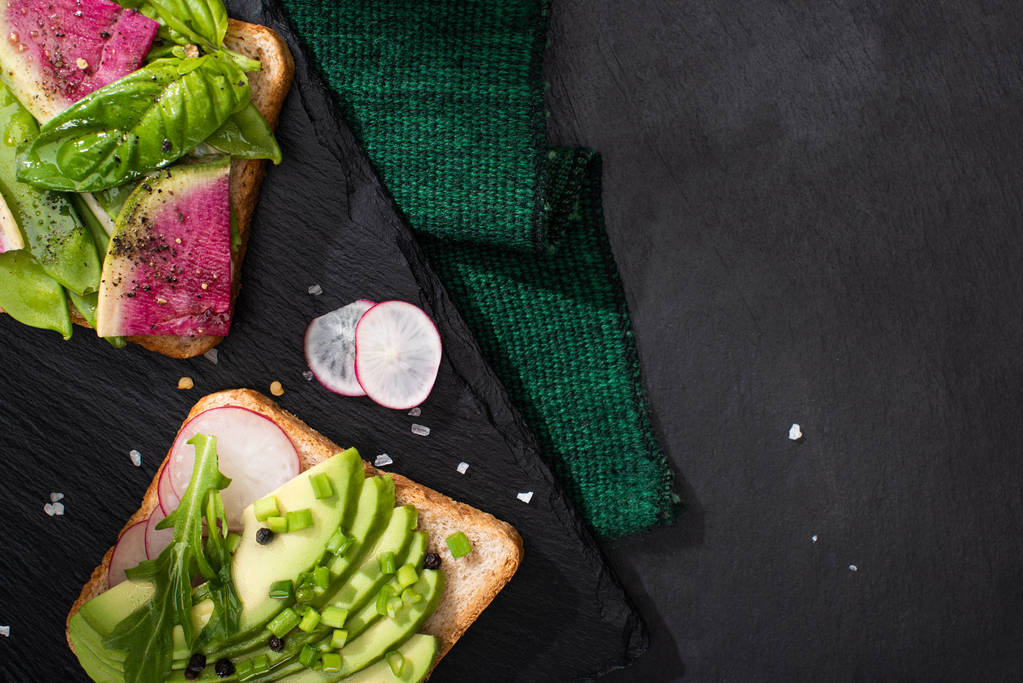 widok z góry wegetariańskie zdrowe kanapki z rzodkiewką i awokado na tkaniny i kamiennej desce - Zdjęcie, obraz