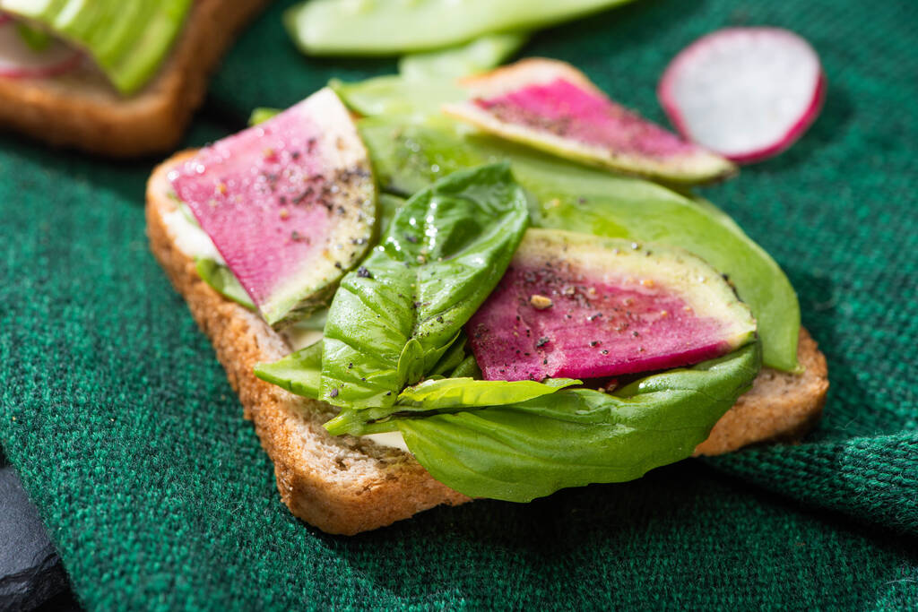 primer plano de sándwiches vegetarianos con rábano, albahaca y aguacate sobre tela
 - Foto, Imagen