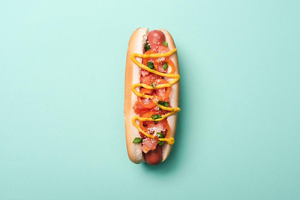 bovenaanzicht van een lekkere hotdog op blauw - Foto, afbeelding
