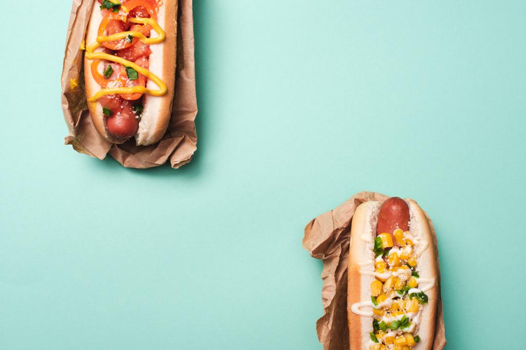 Draufsicht auf zwei Hot Dogs in Papier auf blau - Foto, Bild