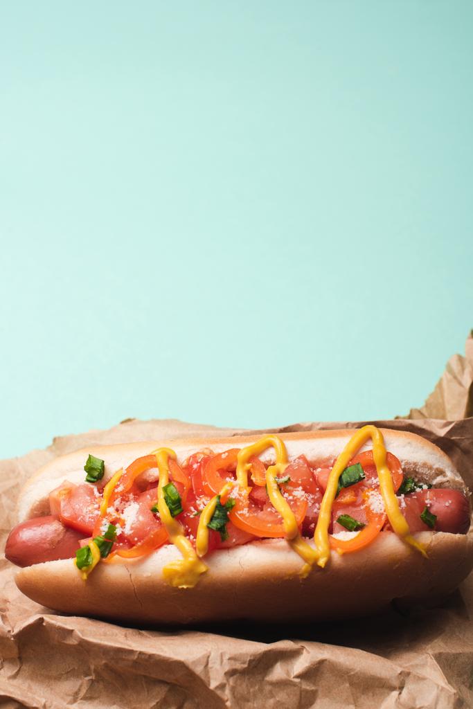 top view of one delicious hot dog in paper isolated on blue - Photo, Image