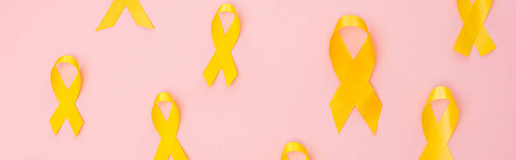 Вид сверху желтых лент на розовом фоне, панорамный снимок, концепция Международного дня борьбы с детским раком
 - Фото, изображение
