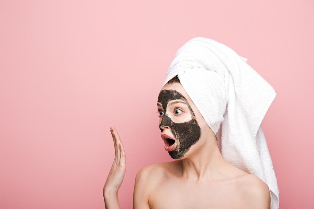 shocked girl with facial clay mask looking away and showing wow gesture isolated on pink - Photo, Image