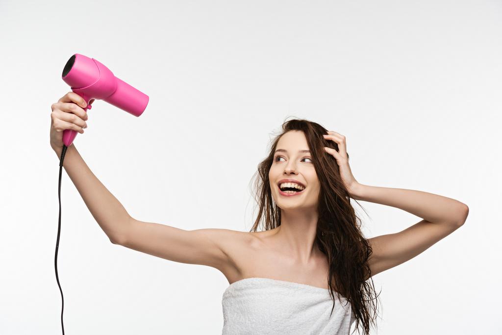 cheerful girl drying long hair with hair dryer isolated on white - Photo, Image