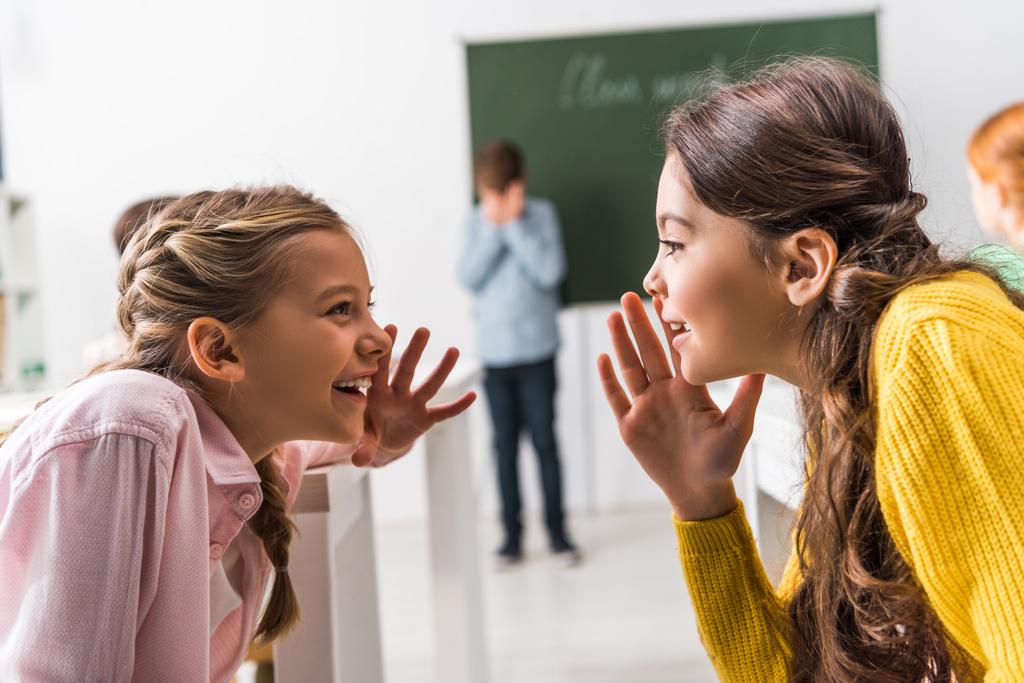 вибірковий фокус школярки пліткує поблизу засмученого однокласника, знущання концепції
  - Фото, зображення