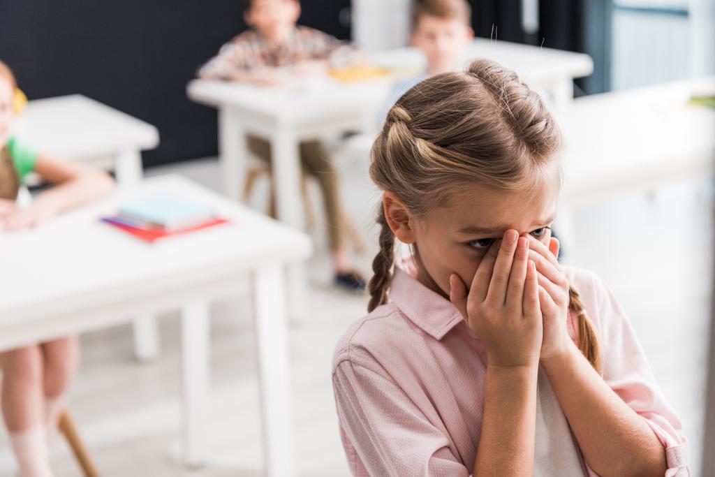 foco seletivo de estudante chateado chorando perto de colegas de classe, conceito de bullying
  - Foto, Imagem