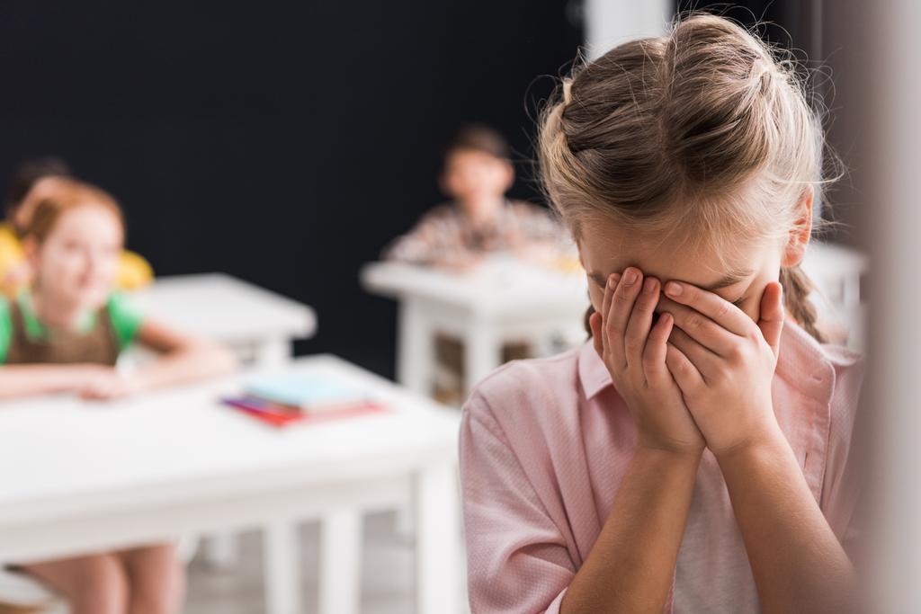selective focus of frustrated schoolkid crying near classmates, bullying concept  - Photo, Image
