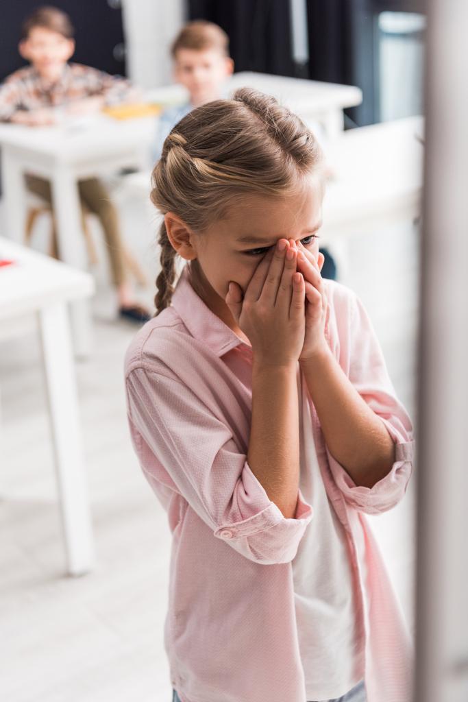 избирательный фокус разочарованного школьника плачущего рядом со школьниками, концепция запугивания
  - Фото, изображение