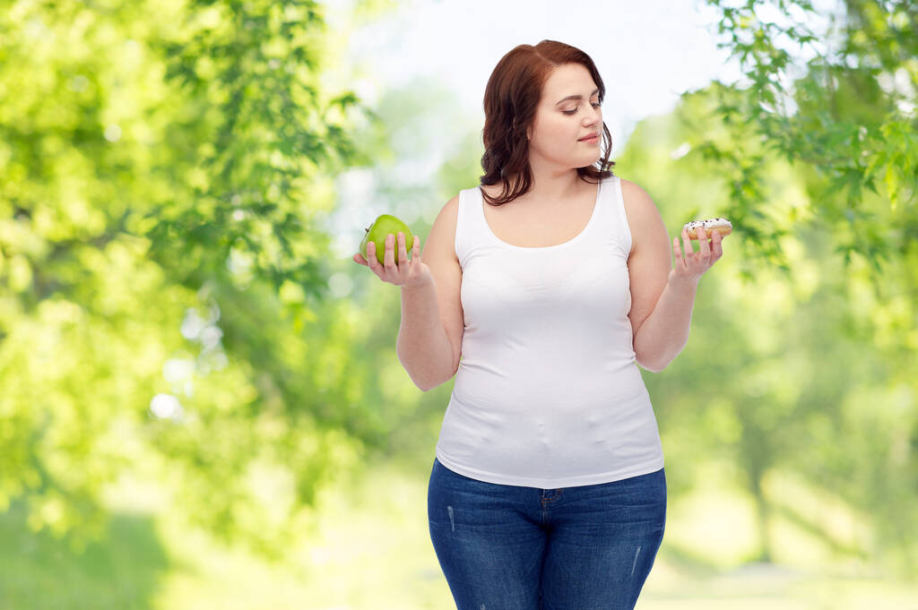 Plus-Size-Frau wählt zwischen Apfel und Donut - Foto, Bild