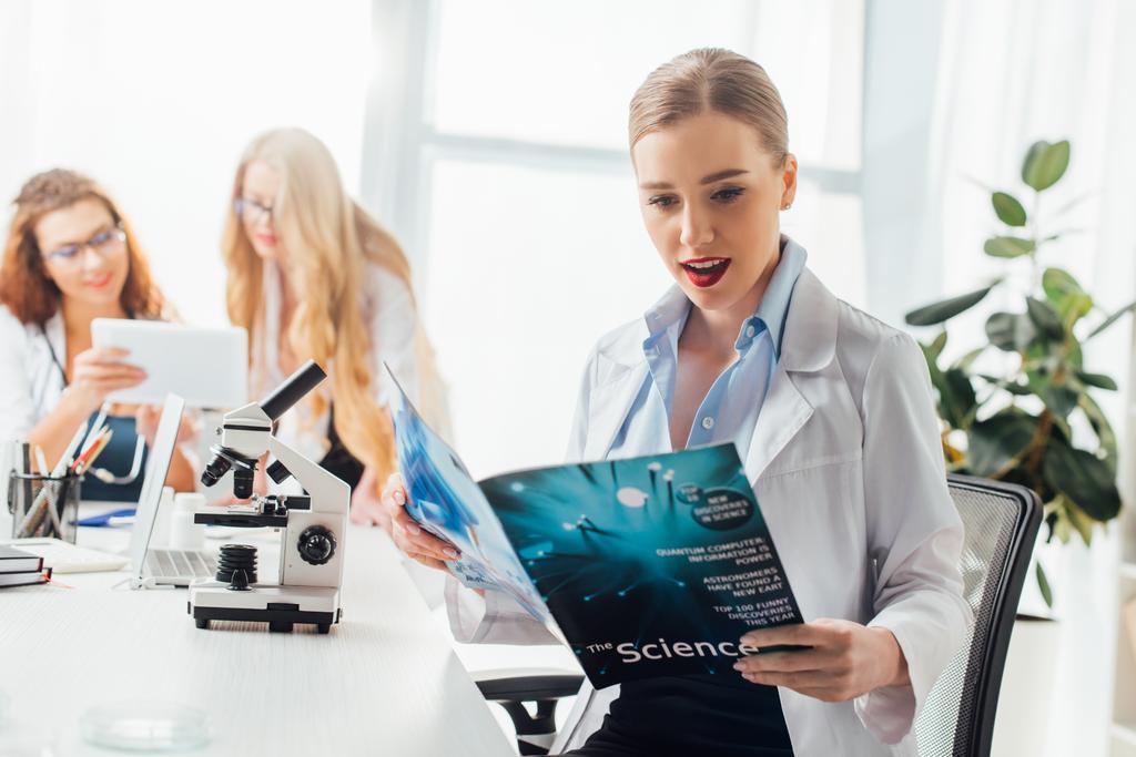 selective focus of sexy nurse reading science magazine near women and microscope  - Photo, Image