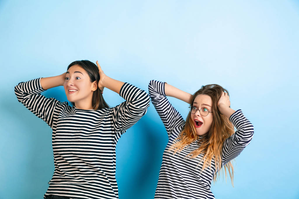Молодые эмоциональные женщины на градиентном синем фоне
 - Фото, изображение