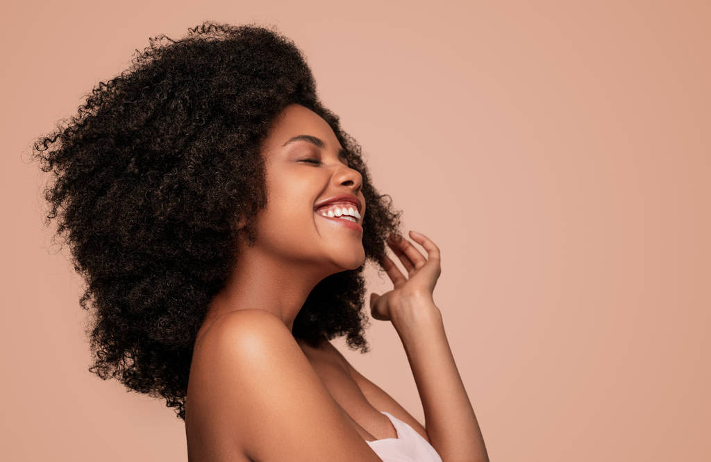 Szczęśliwa młoda Afroamerykanka na różowym tle - Zdjęcie, obraz