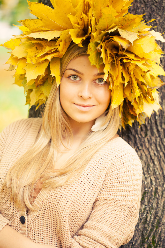 νεαρή γυναίκα, φορώντας ένα στεφάνι του φθινοπώρου φύλλα - Φωτογραφία, εικόνα